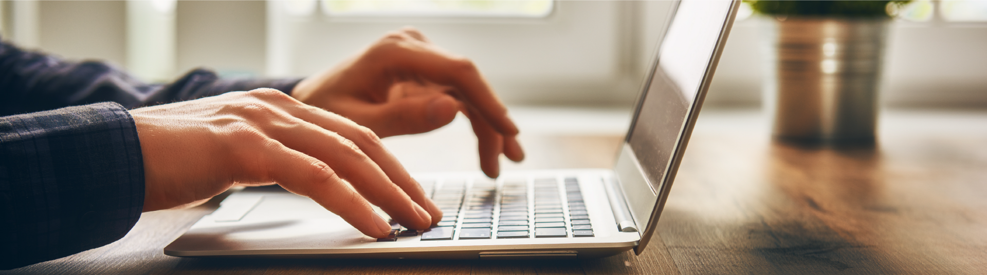 Hands keying a keyboard on a laptop performing a service